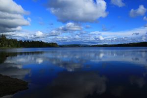 Clouds drift over the blue waters of Lake Ozette