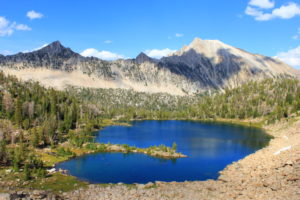 After coming down into the Boulder Chain Lakes basin, Scoop Lake is the first one reached, with a tiny isthmus poking out into the water.