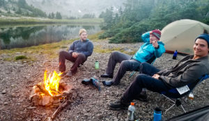 Blair, Kipp, and Joe getting warm by the fire at Warm Lake